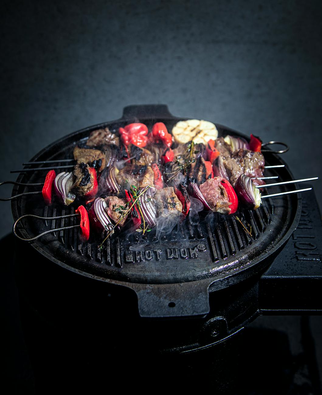 a grilling pan with food on a skewers