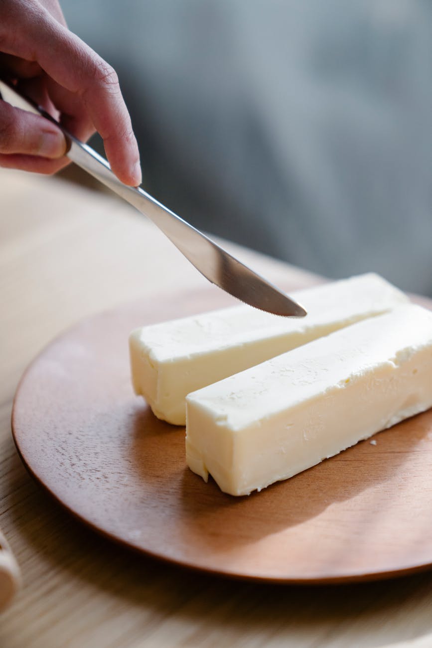 person slicing butter with a knife